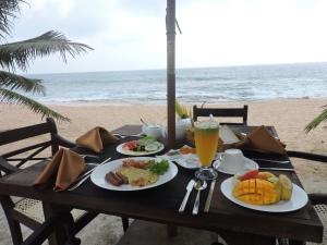 a table with plates of food on the beach at Amanda Beach Villas in Unawatuna