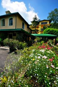 a house with a garden with flowers in front of it at Sterling Park Kalimpong in Kalimpong