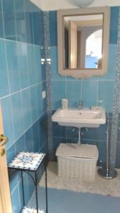 カステルサルドにあるLe Conchiglieの青いタイル張りのバスルーム(シンク、鏡付)