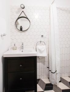 uma casa de banho com um lavatório e um chuveiro com um espelho. em Apartamenty Rynek 10 em Bielsko-Biala