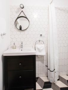 a bathroom with a sink and a shower with a mirror at Apartamenty Rynek 10 in Bielsko-Biala