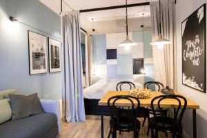 ビェルスコ・ビャワにあるApartamenty Rynek 10の小さなアパートメントで、ダイニングルームテーブル、ベッド1台が備わります。