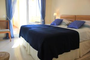 een slaapkamer met een groot bed met blauwe kussens bij Villa Romana Roquetas in Roquetas de Mar +34 foto's