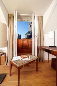 a living room with a bench and a mirror at Louis Hotel in Munich