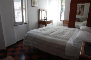 a bedroom with a white bed and a mirror at Hotel Gianni Franzi in Vernazza