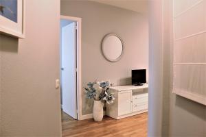 Cette chambre comprend un vase de fleurs et un miroir. dans l'établissement Apartamento Lula, à Saint-Jacques-de-Compostelle