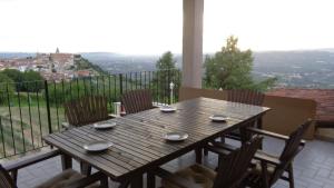 a wooden table and chairs on a balcony with a view at Casa Da Cristina Apartment in La Morra
