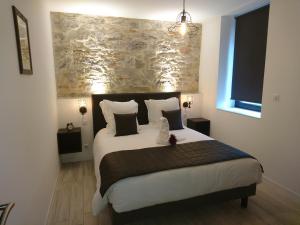 een slaapkamer met een groot bed in een kamer bij Le Moulin d'Oscar & Spa - Mulhouse Nord in Baldersheim