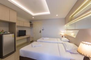 a hotel room with two beds and a television at B-your home Hotel Don Mueang Airport Bangkok 如你家酒店 in Bangkok