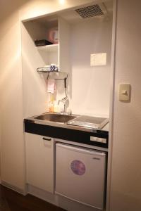 una piccola cucina con lavandino e bancone di Hotel Yumeya a Fukuoka