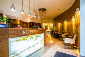 un restaurante en el vestíbulo con una recepción y sillas en WELLNESS HOTEL LÖWE, en Piešťany