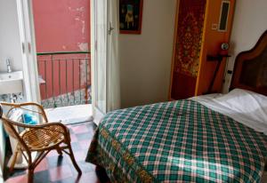 a bedroom with a bed and a chair and a window at Hotel Gianni Franzi in Vernazza
