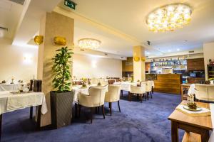 a dining room with white tables and chairs at WELLNESS HOTEL LÖWE in Piešťany