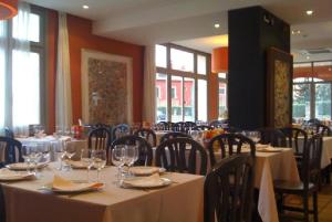 una sala da pranzo con tavoli e sedie con bicchieri da vino di La Posada del Rancho a Segovia