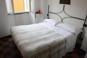 a bedroom with a bed with a striped blanket at Hotel Gianni Franzi in Vernazza