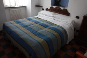 a bed in a room with a white bedspread at Hotel Gianni Franzi in Vernazza