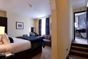 a hotel room with a bed and a couch at The Marble Arch Suites in London