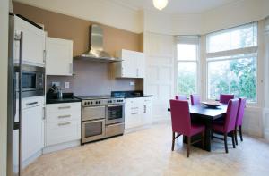 a kitchen with a table and purple chairs in it at Eildonside in Melrose