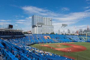 um estádio de basebol com assentos azuis e um jogo de basebol em Nihon Seinenkan Hotel em Tóquio