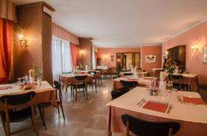 ガッリオにあるHotel Concordiaのテーブルと椅子が備わるレストラン