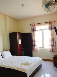a bedroom with a bed and a window at Hotel Tan Phu in Lagi