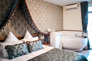a hotel room with a large bed and a bathtub at Radailiu Dvaras - Dinosaur Park in Radailiai