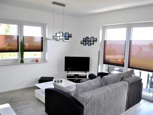 a living room with a couch and a tv at Ferienwohnungen am Hafen in Stahlbrode