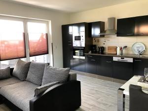 a living room with a couch and a kitchen at Ferienwohnungen am Hafen in Stahlbrode