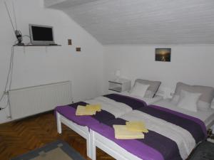 two beds in a room with purple and yellow towels on them at Rooms Mila in Rezovac