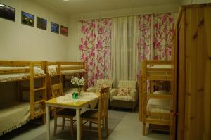 a room with bunk beds and a table and chairs at Aneen Loma Vacation and Cottages in Anetjärvi