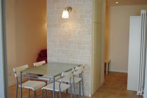 tavolo e sedie in una stanza con muro di mattoni di Bizio Apartment a Sirolo
