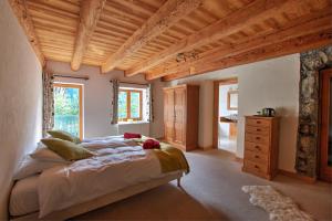 una camera con un grande letto e un soffitto in legno di La Ferme du Château a La Chapelle-dʼAbondance