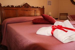 サレルノにあるDaniel and Jamesのベッド(タオル、枕、赤い弓付)