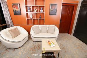 uma sala de estar com duas cadeiras brancas e uma mesa em Swiss Lenana Mount Hotel em Nairobi
