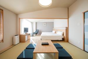 une chambre d'hôtel avec un lit et une table dans l'établissement Clayton Bay Hotel, à Kure