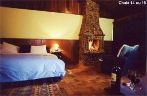 a bedroom with a bed and a fireplace at Pousada no Caminho do Marimbondo in Visconde De Maua