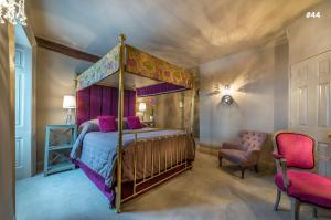sypialnia z łóżkiem z baldachimem i krzesłem w obiekcie The George Hotel of Stamford w mieście Stamford