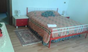ein Schlafzimmer mit einem Bett mit rotem Gestell und zwei Tischen in der Unterkunft Locanda Amato in Amato