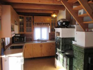 eine Küche mit Holzschränken, einem Waschbecken und einem Fenster in der Unterkunft Zrub pri Jazierku in Jazernica