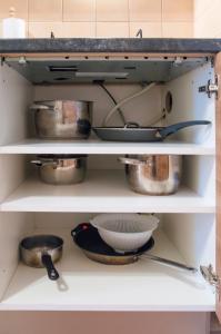 a shelf in a kitchen with pots and pans at Modern Apartment Krakovska in Prague