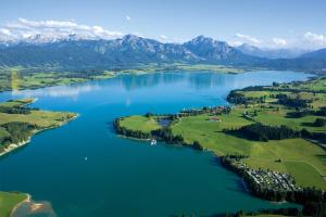 an aerial view of a lake with mountains at Seehotel und Appartements Schnöller in Rieden am Forggensee
