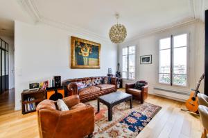 a living room with a couch and a guitar at Hôtel de ville in Levallois-Perret