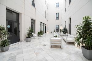 un cortile in un edificio con piante in vaso di Petit Palace Marques Santa Ana a Siviglia