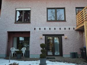 een huis met twee ramen en een tafel en stoelen bij Cozy Apartment in County of Manderscheid with TV in Manderscheid