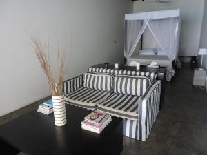 a living room with two striped couches and a table at Galle Henna Beach House in Unawatuna