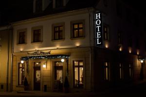 a building with a lit up sign in the night at HG Hotel in Toszek