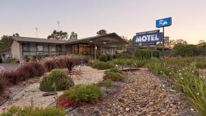 a motel with a sign in front of a building at Castle Creek Motel in Euroa