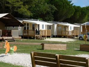 een rij stacaravans met een paard in het zand bij Camping Les Chênes Verts in Meschers-sur-Gironde