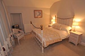 a bedroom with a large bed and a chair at Bryn Tirion in Morfa Nefyn