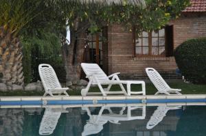 2 tumbonas y una piscina frente a una casa en Posada el Paraiso en San Luis